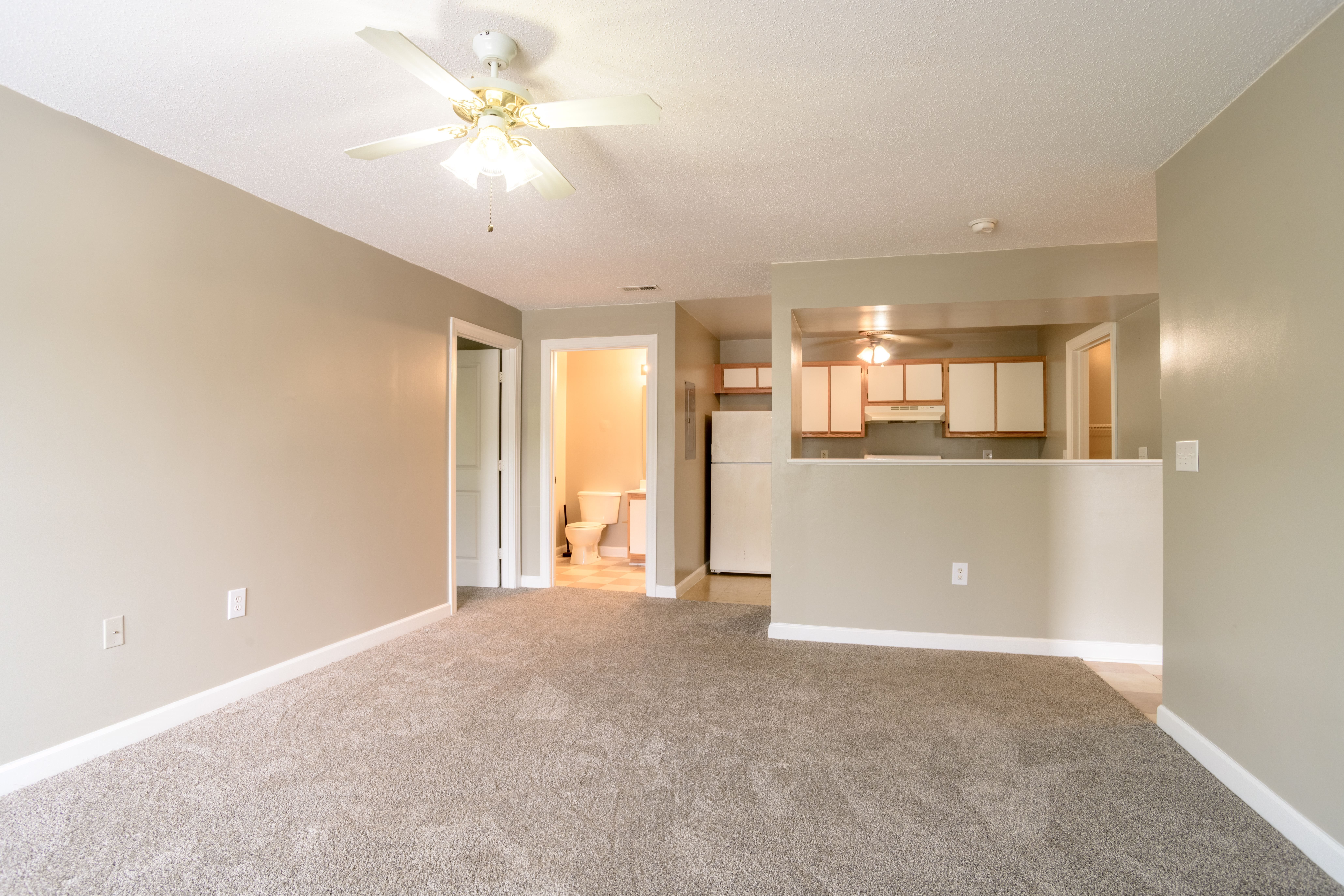 A living room with a carpeted floor and a ceiling fan.,A living room with a carpeted floor and a ceiling fan.